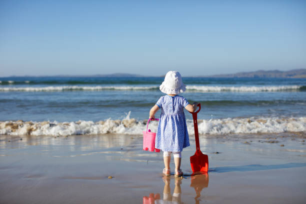 rear view of baby girl playing at summer beach, Donegal, Ireland
