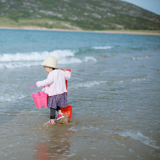istock baby girl playing at summer beach 997173970