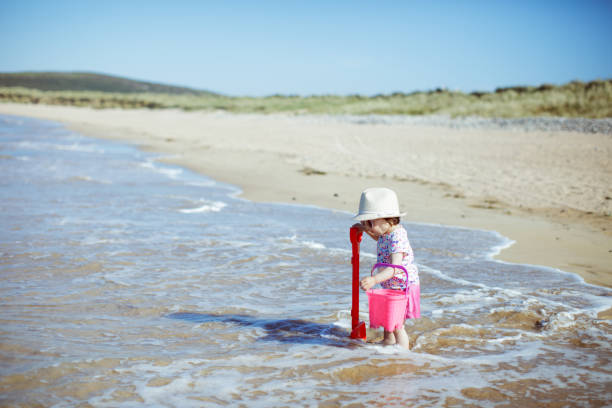 istock baby girl playing at summer beach 997174062