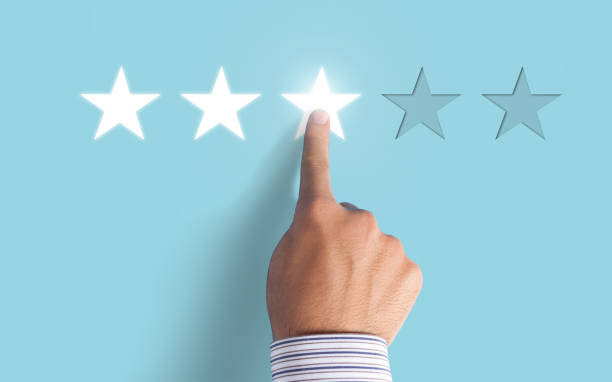 istock Hand choosing 3 stars rating on blue background - Average feedback concept 997176546