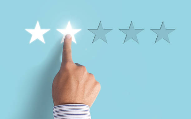 istock Hand choosing 2 stars rating on blue background 997176548