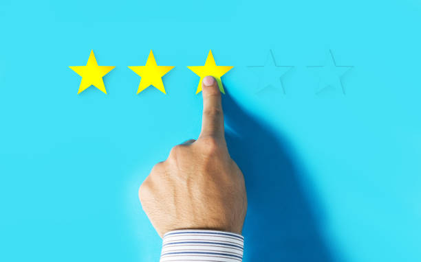 istock Hand choosing three stars rating on blue background 997176550