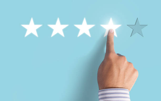 istock Hand choosing 4 stars on blue background - Good feedback concept 997176552