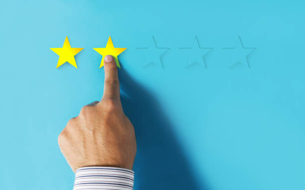 istock Hand choosing 2 stars rating on blue background 997178616