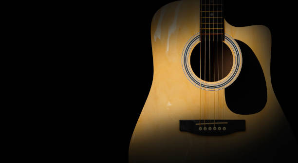 istock Part of acoustic guitar on old black background 997212614