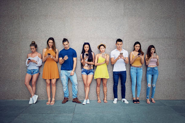 istock Friends are texting standing at the wall 997220204