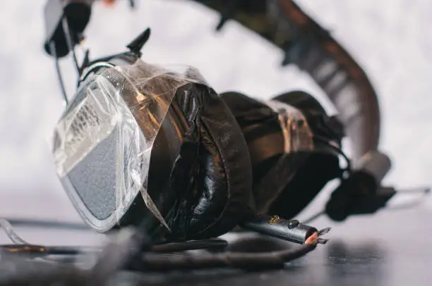 Photo of Damaged headphones on the wooden table with sellotape