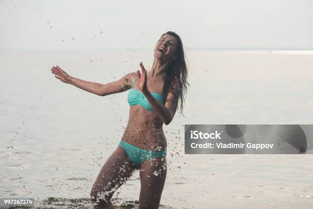 Photo libre de droit de Fille En Maillot De Bain Posant Dans La Mer En Samusant Et En Jouant Dans Leau banque d'images et plus d'images libres de droit de A la mode