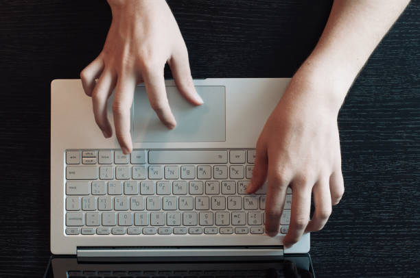 mesa de madeira vista superior, masculinas mãos digitando no teclado portátil - human hand computer keyboard male netbook - fotografias e filmes do acervo
