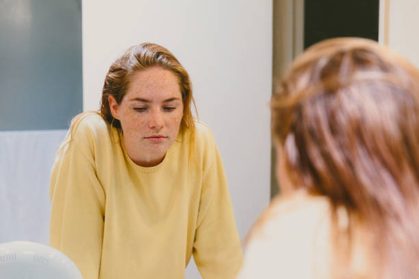 Depressed Woman Looks in Bathroom Mirror