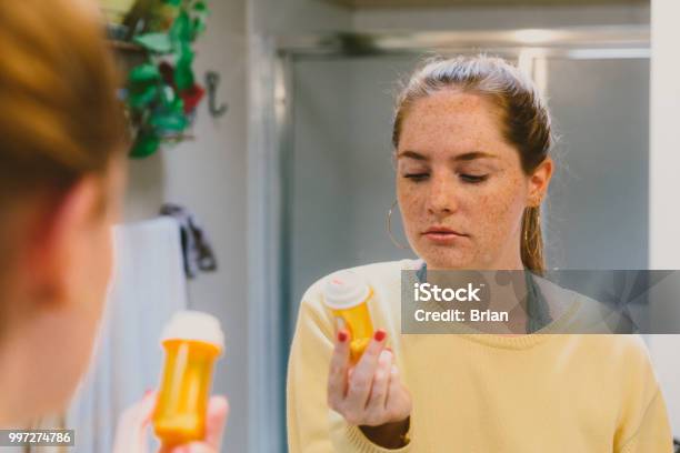 Woman Reading Pill Bottle Label Stock Photo - Download Image Now - Medicine, Teenager, Bottle