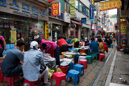 Busan, Korea - July 7th 2018, People having lunch on the aisle at the Gwangbok-dong Food Street, Busan Korea. 부산 광복동 먹자 골목
