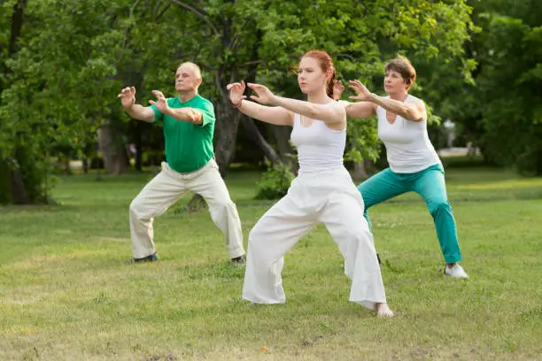 group of people practice Tai Chi Chuan in a park.  Chinese management skill Qi's energy.