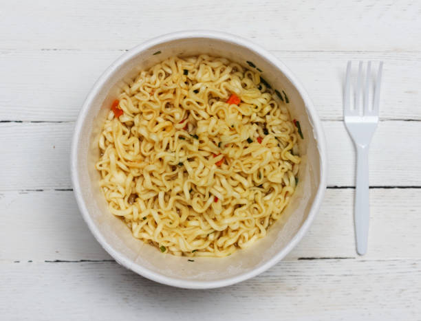 istock instant noodles on wooden background, top view close-up 997355470
