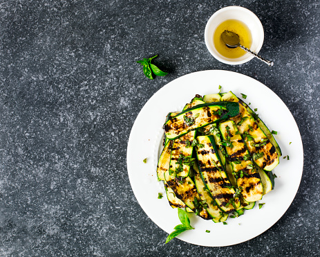 Grilled zucchini with basil and olive oil, top view