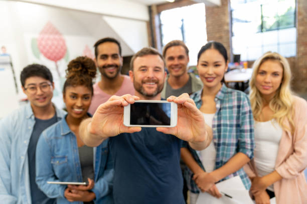 istock Happy group of workers taking a selfie at the office 997374182