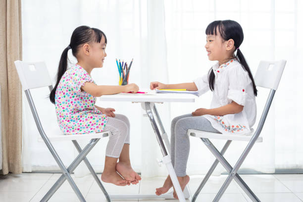 Asian Little Chinese sisters doing homework at home