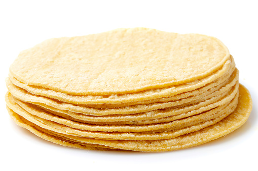 Stack of Organic vegan  yellow corn tortillas on white background