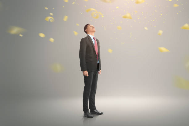 istock Young asian businessman looking up with falling confetti 997381192