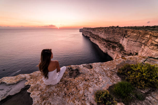 istock Woman overlooks the Ta Cenc cliffs at sunset.  Gozo, Malta 997396344