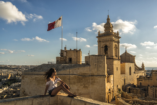 A woman overlooks the capital city of Victoria (Rabat) on the island of Gozo, Malta
