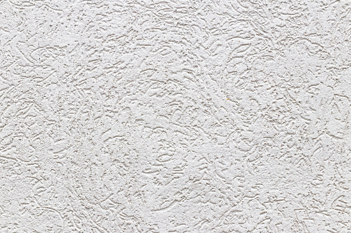 Texture of a fragment of a wall of a modern structure of white color. Harshness in the style of bark beetle.A background for design and creative work. Decoration and exterior decoration of the build