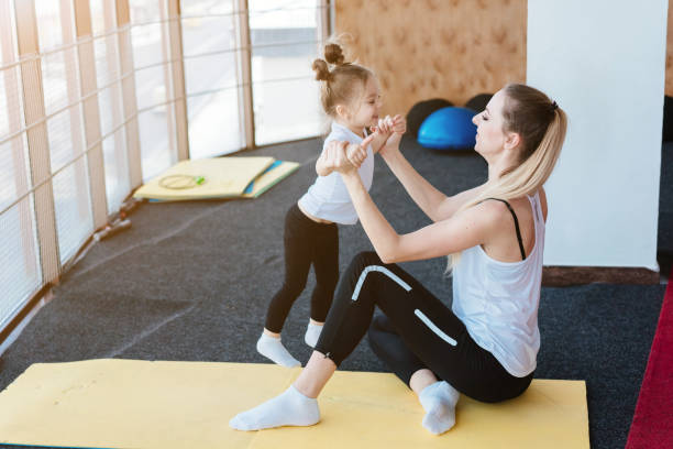 istock Mom and daughter together perform different exercises 997420714