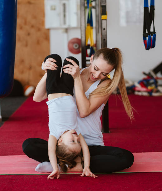 istock Mom and daughter together perform different exercises 997421516