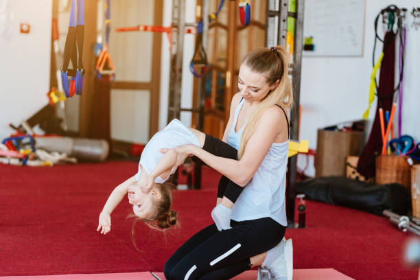 istock Mom and daughter together perform different exercises 997423580