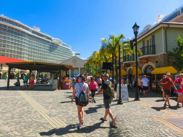 The people going at port Falmouth, Jamaica - May 02, 2018: The people going at Falmouth port in Jamaica island, the Caribbeans. Port with old houses, duty free zone, cruise ship liner Oasis of the Seas by Royal Caribbean docked at port. falmouth harbor stock pictures, royalty-free photos & images