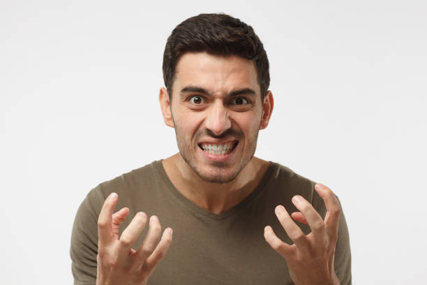istock Shut up concept. Mad young man bite his teeth, gesturing with hands. Studio portrait of angry and irritated male yelling, looking crazy and full of anger 997462230