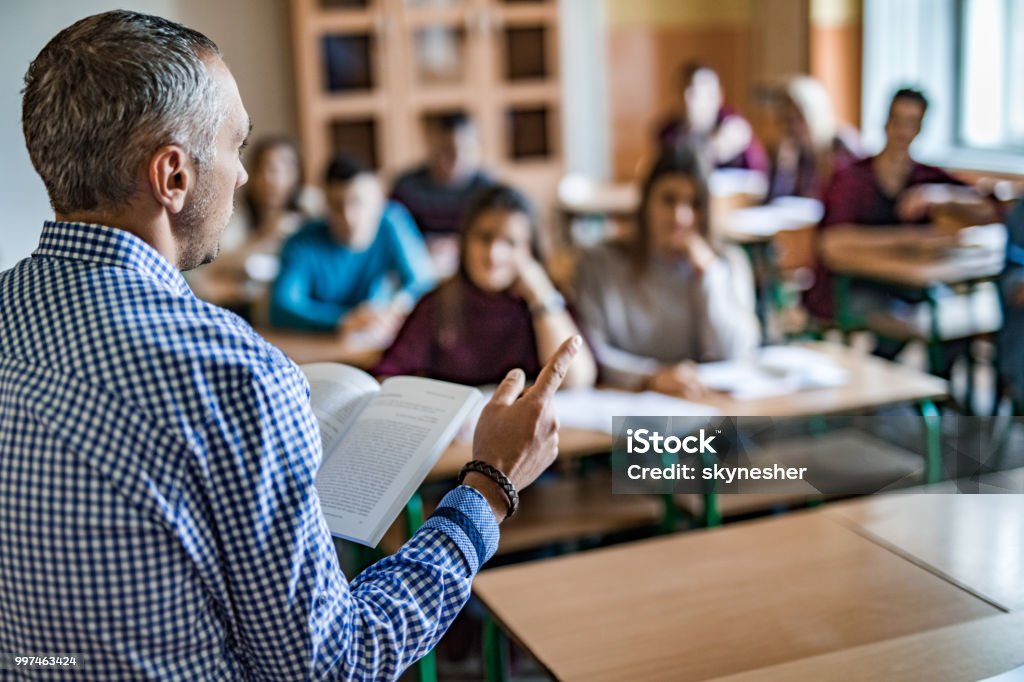 Insegnante di scuola superiore che dà lezioni in classe. - Foto stock royalty-free di Lettore