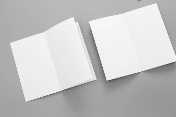 istock Blank portrait A4. brochure magazine isolated on gray, changeable background / white paper business card isolated on gray 997487100