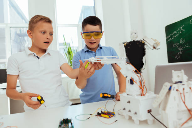 istock Smart young boys standing in the classroom 997490508