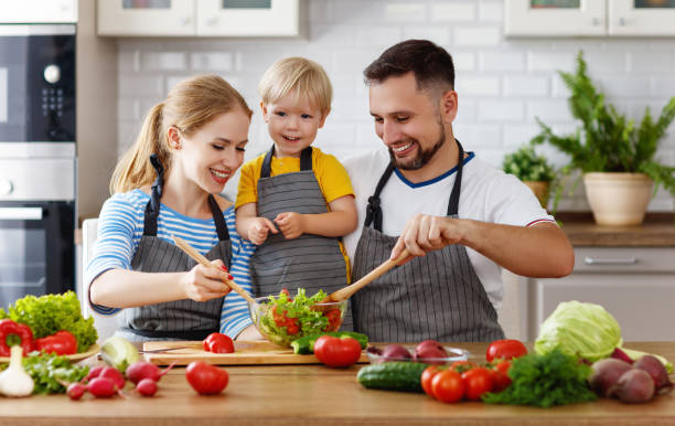 istock happy family with child  preparing vegetable salad 997490644