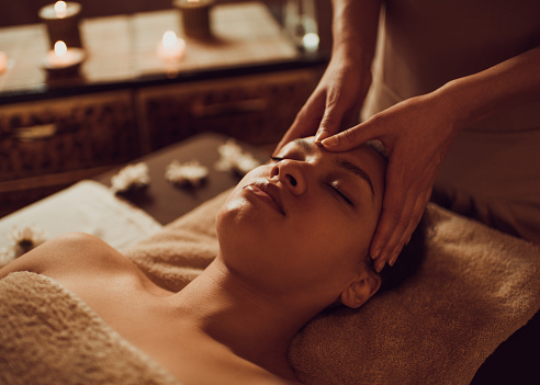 Relaxed black woman having head massage at the spa.