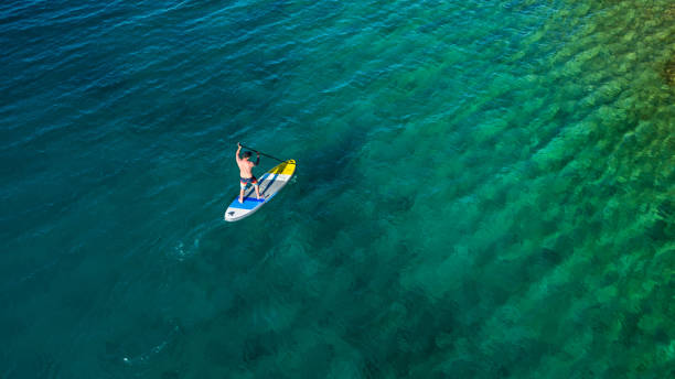 istock Aerial view of young man riding paddleboard 997508912