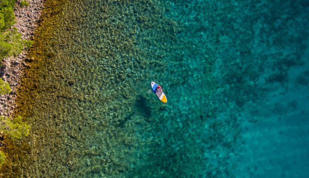 istock Aerial view of young man riding paddleboard 997509112