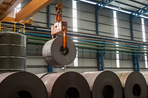 Image of crane loading of metal steel rolls.