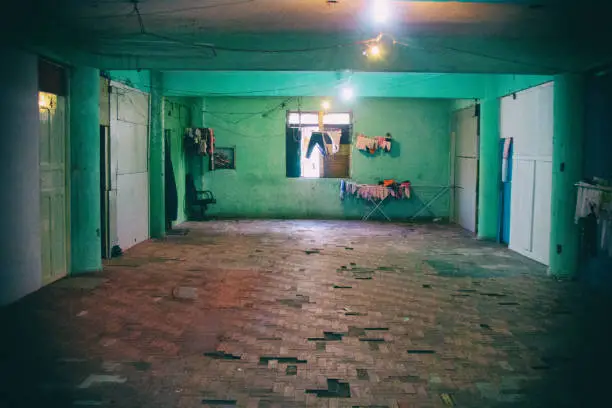 Drying clothes can be seen near a window in this floor with green walls and red floor of a ruined occupied building by a social housing movement.