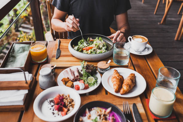 istock View from above on table with fresh breakfast. Man hands holding fork and knife 997521960