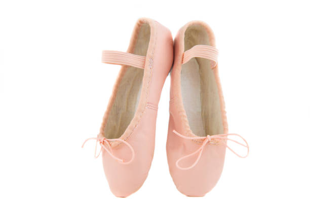 isolated pair of beginner ballerina shoes placed on tiptoes stock photo