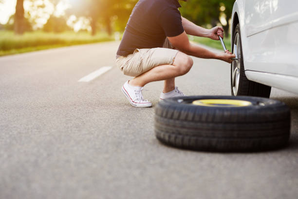 istock The man changes the tire to a broken car 997523666
