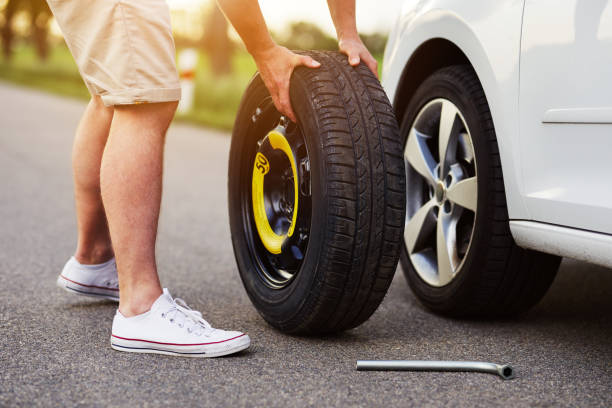 istock The man changes the tire to a broken car 997523672