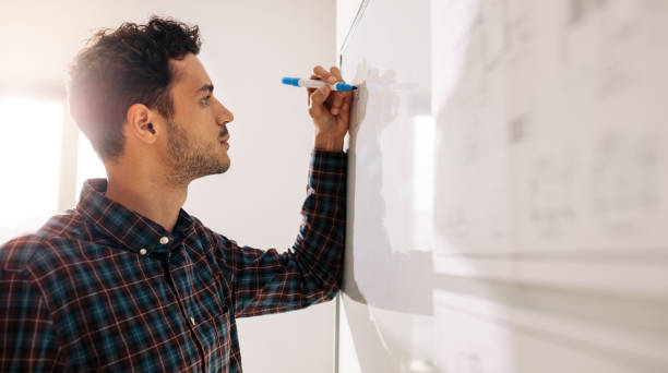 istock Businessman writing on whiteboard in office 997527642