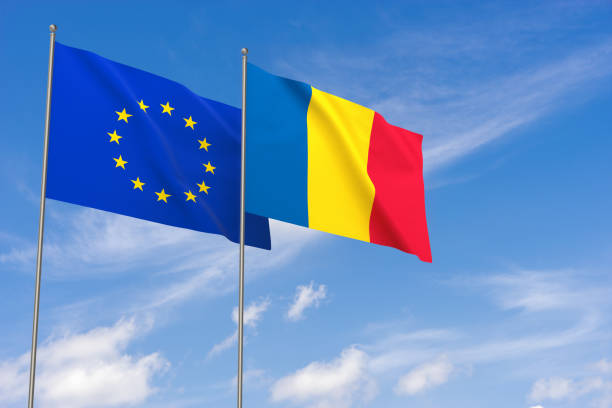 istock European Union and Romania flags over blue sky background. 997531486