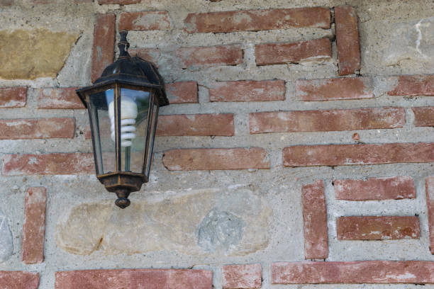exterior light fixture mounted on brick wall with copy space. Energy saving light bulb installed.