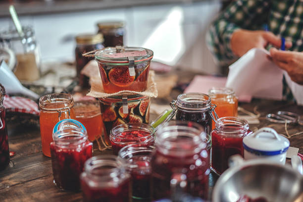 vorbereitung, hausgemachte erdbeere, heidelbeere und himbeermarmelade und canning in gläsern - jar canning food preserves stock-fotos und bilder