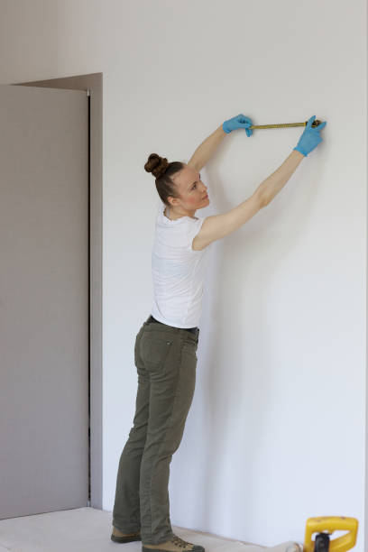 istock Young ladyis measuring the wall to stall something 997536444