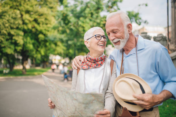 istock Man hugging his wife and looking touristic map in her hands 997548600